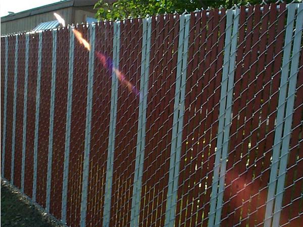 This are chain link fence with slats that the slats are passing through chain link fence vertically.