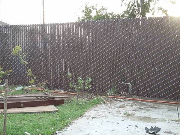 This is a yard that has chain link fence with slats.