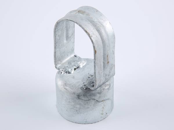 A piece of galvanized line post cap on gray background.
