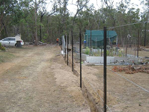 The construction site is surrounded by fence that is made of many star pickets and steel wires.