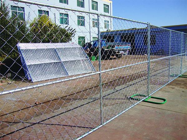 Temporary chain link fence with green fence feet installed in the factory yard.