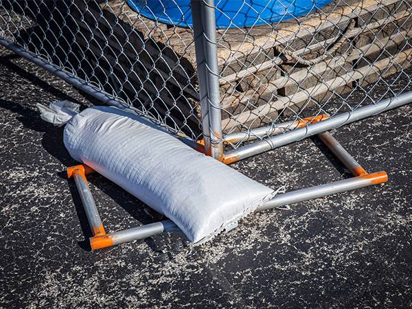 There is a sand bag used to weight down the temporary chain link fence panels.