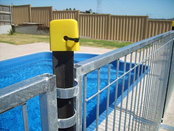 A black star pickets with yellow plastic cap are connecting temporary pool fencing.